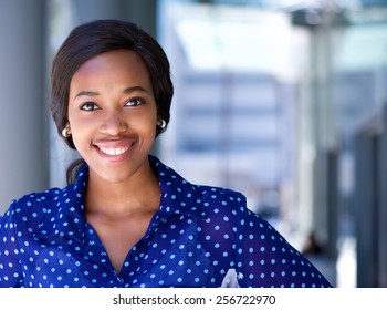 Close up portrait of a happy business woman smiling outside office building - Shutterstock ID 256722970