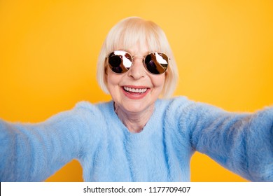 Close Up Portrait Of Happy Grandma Taking A Selfie On Vacation Of Two Hands, Isolated On Yellow Background