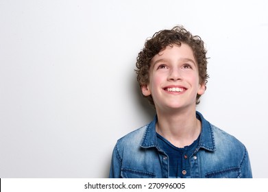 Close up portrait of a happy little boy looking up on white background 
