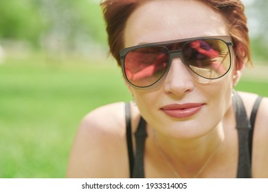 Close Up Portrait Happy Mature Woman With Redhead Short Haircut  In Modern Sunglasses In Summer Park. Summer Mood.