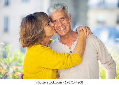 Close Up Portrait Happy Older Couple With Woman Kissing Man