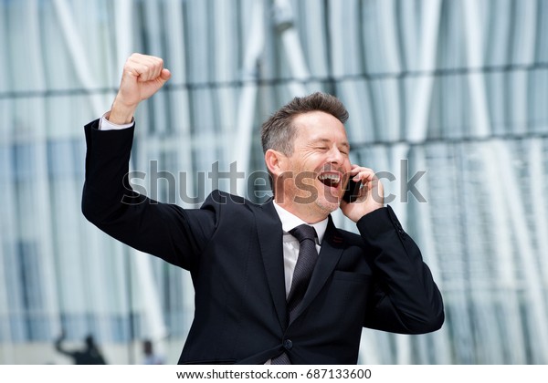 Close up portrait of happy older man with fist\
raised on business call