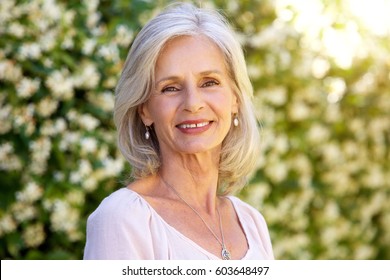 Close Up Portrait Of Happy Older Woman Standing Outside In Summer