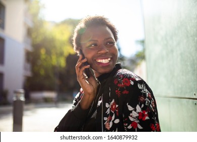 Close up portrait happy young african woman talking with cellphone outside - Shutterstock ID 1640879932