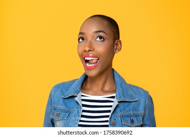 Close Up Portrait Of Happy Young African American Woman Rolling Her Eyes Looking Up With Mouth Open In Isolated Studio Yellow Background