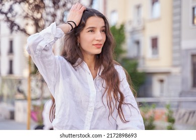 Close Up Portrait Of A Happy Young Caucasian Woman With Fresh Clean Skin Standing Outside. Brunette Woman Is Touching Hair . Lifestyle, Female Beauty Concept.