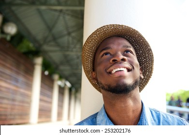 Close up portrait of a happy young man smiling and looking up - Shutterstock ID 253202176