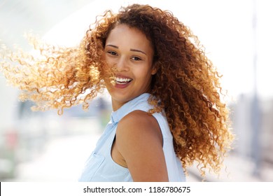 Close up portrait of happy young woman with curtly hair turning around - Shutterstock ID 1186780675