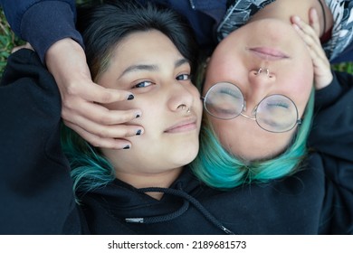 Close up portrait with high angle view of a lesbian couple lying on the grass