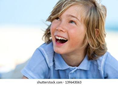 Close Up Portrait Of Laughing Boy Looking At Corner Outdoors.