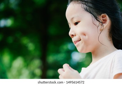 Close Up portrait of little asian girl with dimples in park