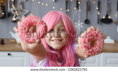 Close up Portrait of a little smiling girl with pink hair and two appetizing donuts in her hands, on a kitchen background. Vanilla Girl. Kawaii vibes. banner
