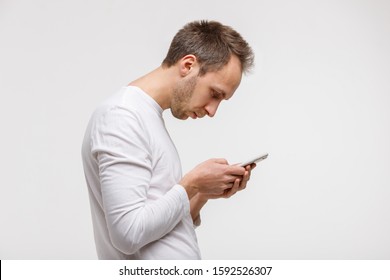 Close up portrait of man looking and using smart phone with scoliosis, side view, isolated on gray background. Rachiocampsis, kyphosis curvature of neck, Incorrect posture, , 
orthopedics concept