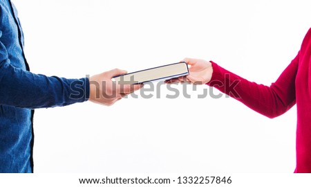 Close up portrait of man and women students exchanging books isolated on white. Literature sharing between people. Give to read to a friend as present. Person borrow textbook, swap of knowledge.