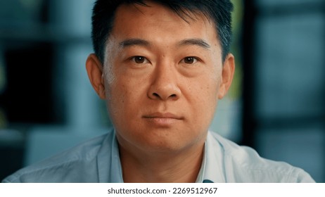 Close up portrait mature Asian man 40s businessman boss employer lawyer leader middle-aged senior Chinese Japanese Korean male posing in modern office looking at camera serious unhappy face expression - Powered by Shutterstock