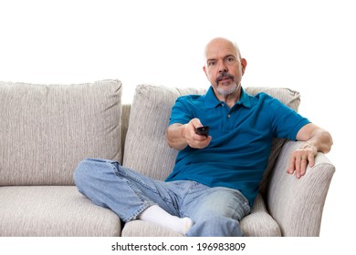 Close Up Portrait Of Mature Man Sitting On The Couch Using Remote Isolated On White