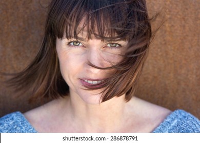 Close Up Portrait Of A Mature Woman With Hair Blowing In Wind