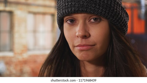 Close up portrait of millennial woman wearing beanie on urban city street - Shutterstock ID 1171968439