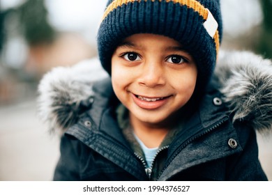 close up portrait of mixed race cute happy smiling child on a cold winter day 