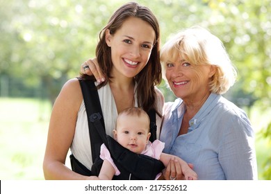 Close Up Portrait Of A Mother And Grandmother Smiling With Baby