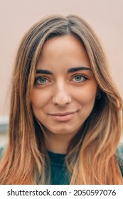 Close Up Portrait Of Natural Beauty Caucasian Young Woman With Long Light Brown Hair And Green Eyes Hinting At A Sly Smile