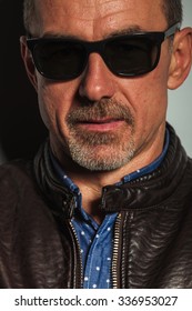 Close Up Portrait Of An Old Casual Man In Leather Jacket And Sunglasses , Studio Picture