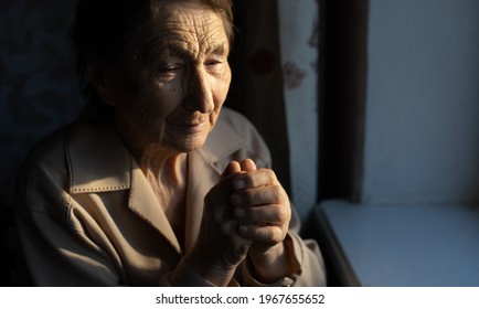 Close Up Portrait Of An Old Woman Praying