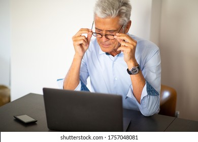 Close Up Portrait Older Businessman With Glasses Sitting In Office Looking At Laptop Computer