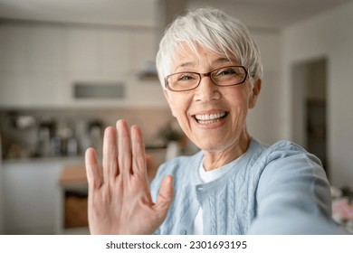 Close up portrait of one senior woman with short hair happy smile positive emotion copy space standing at home indoor gray white hair self portrait selfie or video call - Powered by Shutterstock