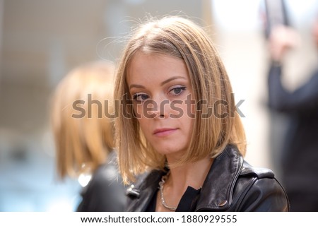 Close up portrait of a pensive and daydreaming beautiful blonde woman. Selective focus