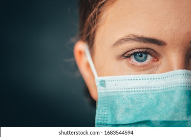 Close up portrait photo, Eye of Yong Female Doctor. Protection against contagious disease, coronavirus, hygienic face surgical medical mask to prevent infection. Black background - Shutterstock ID 1683544594