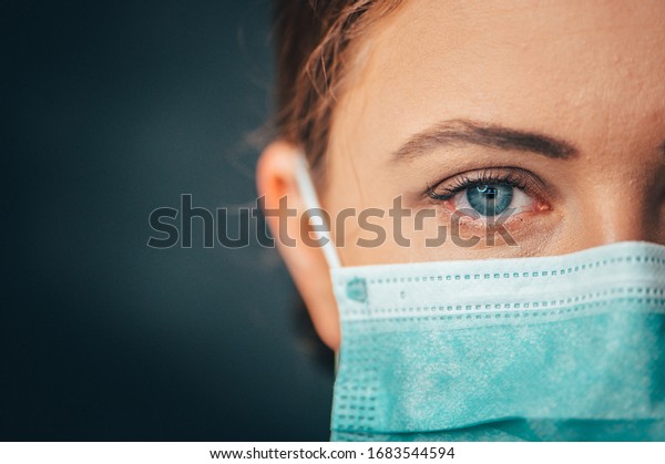 Close up\
portrait photo, Eye of Yong Female Doctor. Protection against\
contagious disease, coronavirus, hygienic face surgical medical\
mask to prevent infection. Black\
background