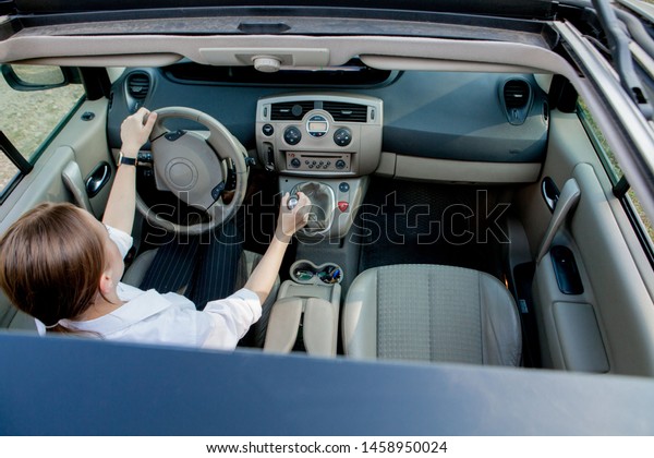 Close up portrait of pleasant looking female\
with glad positive expression, being satisfied with unforgettable\
journey by car, sits on driver s seat. People, driving, transport\
concept.