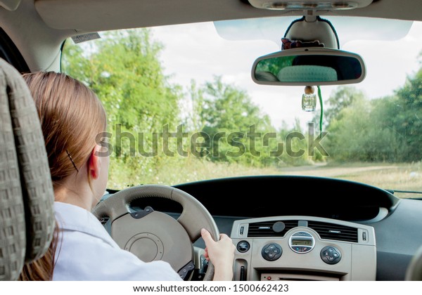 Close up portrait of pleasant looking female\
with glad positive expression, being satisfied with unforgettable\
journey by car, sits on driver s seat. People, driving, transport\
concept.