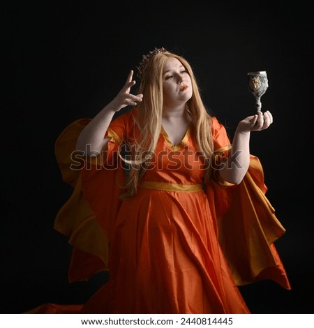 close up portrait of plus sized blonde woman, wearing historical medieval fantasy gown, crowned royal queen.  posing holding wine cup drinking goblet, isolated dark black studio background.
