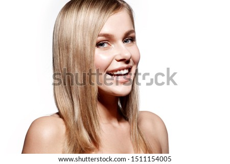 Close up portrait of pretty model with straight blonde hair and bare shoulders. Cute girl with shining fresh skin looking at camera with happiness. Isolated on white copy space in right side