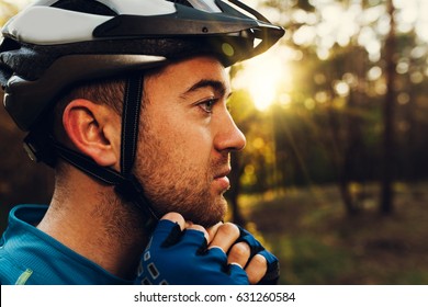 Close Up Portrait In Profile Of Handsome And Serious Cyclist Close His Protective Helmet Outdoors And Looking Away, Thinking About The Route. Travel. Sport Lifestyle
Young Rider Wearing Blue T-shirt.