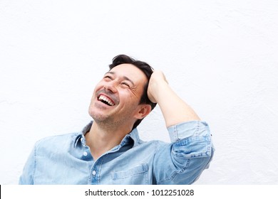 Close Up Portrait Of Relaxed Older Man Laughing With Hand On Head Against White Background