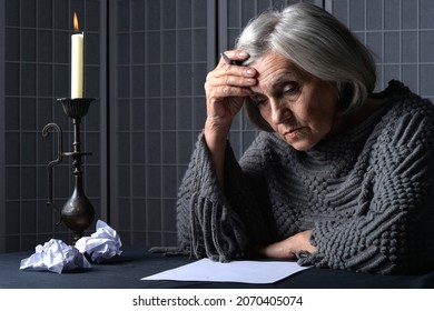 Close Up Portrait Of Sad Senior Woman Writing Letter