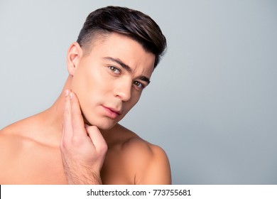 Close up portrait of satisfied confident handsome guy touching with shaved flawless clean soft skin after morning shaving, isolated on grey background, copy-space