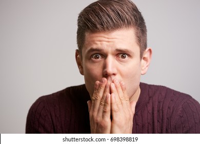 Close Up Portrait Of A Scared Young Man With Hands To Face