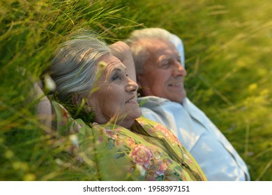 Close up portrait of senior beautiful woman lying on grass