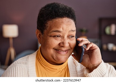 Close up portrait of senior woman calling by smartphone in home setting and smiling cheerfully talking to loved ones - Powered by Shutterstock