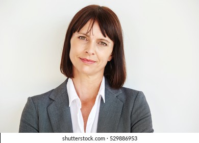 Close Up Portrait Of Serious Business Woman Standing By White Wall