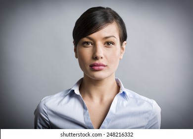 Close Up Portrait Of Serious, Confident Businesswoman Looking Straight, Isolated On Grey Background.