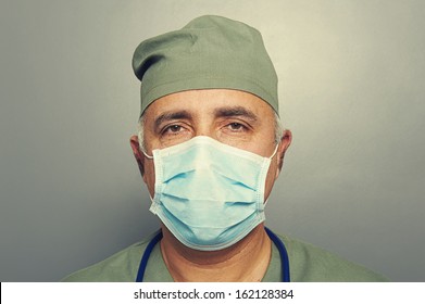 Close Up Portrait Of Serious Doctor In Mask Over Dark Background