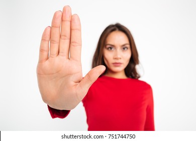 Close Up Portrait Of A Serious Young Asian Woman Showing Stop Gesture With Hand Isolated Over White Background