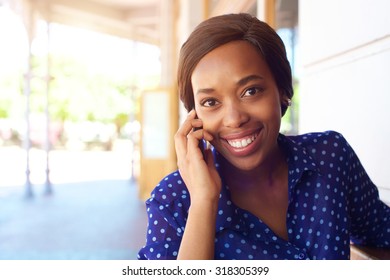 Close up portrait of a smiling african american business woman using cell phone - Shutterstock ID 318305399