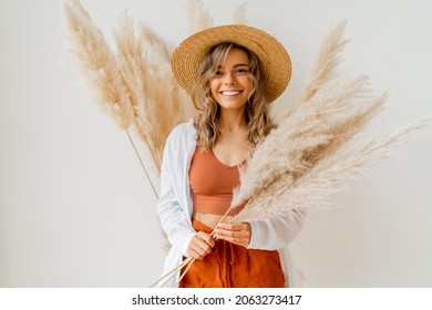 Close up portrait of smiling  blond woman with perfect smile in stylish boho autfit. Posing in inerior studio over white background.