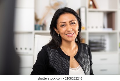 Close up portrait of smiling confident hispanic female office employee ..